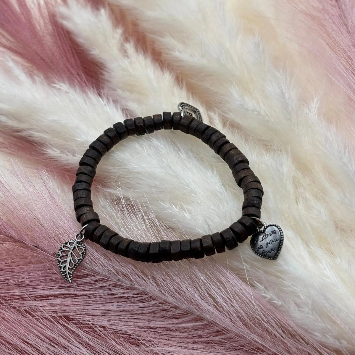 Bracelet en perles artisanal avec breloques cœurs et perles plates en bois sur élastique