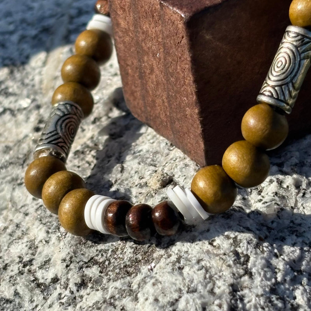 Vue de près d'un bracelet en perles artisanal avec perles de bois marron vert et perles acryliques allongées et rondes sur élastique