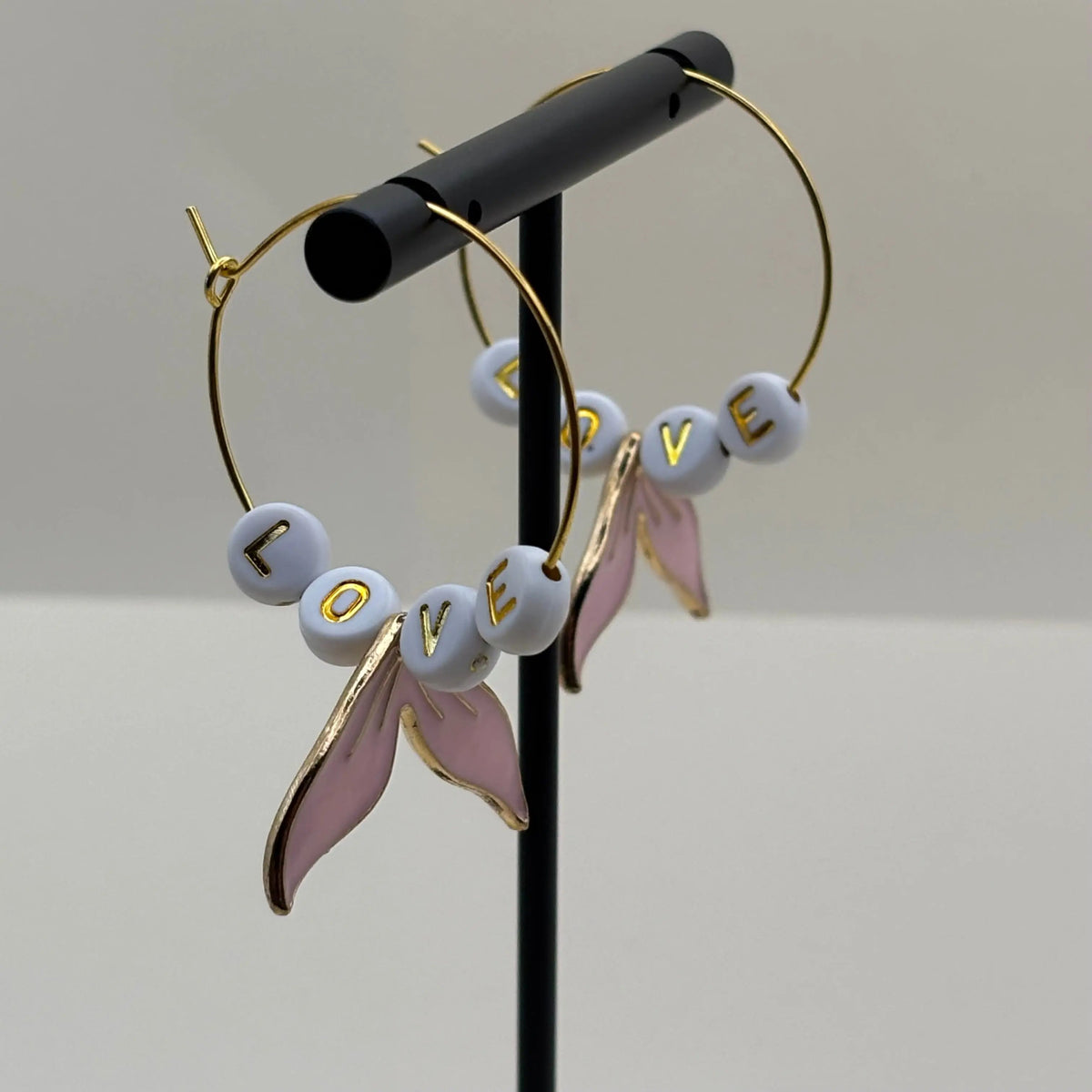 Boucles d'oreilles créoles dorées avec queue de baleine rose et mot love 