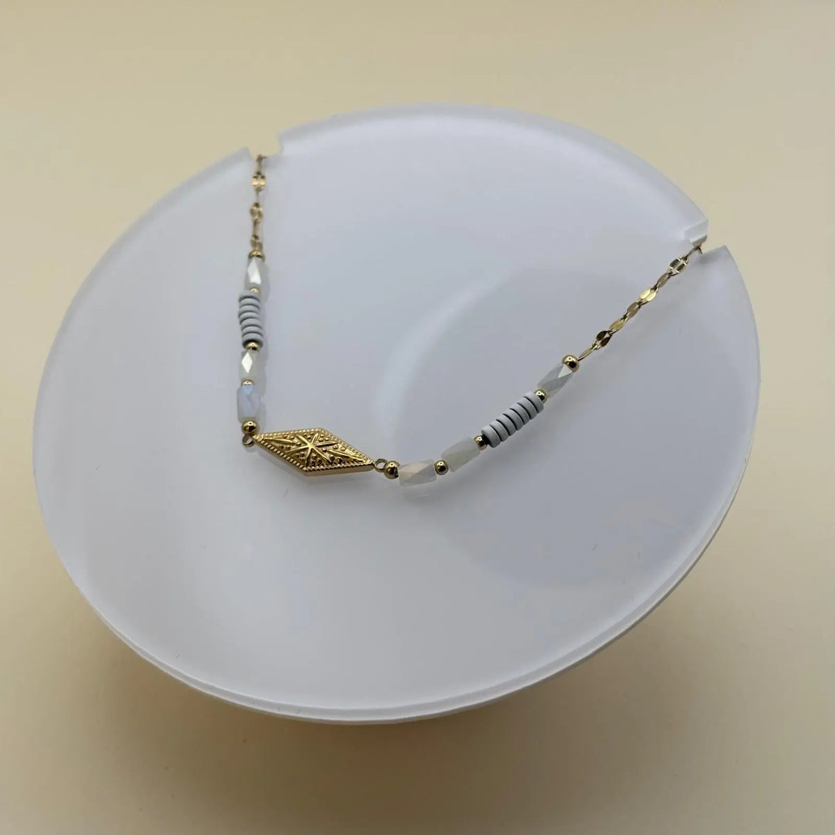 Bracelet fantaisie avec  de petits maillons dorés avec une breloque rose des vents