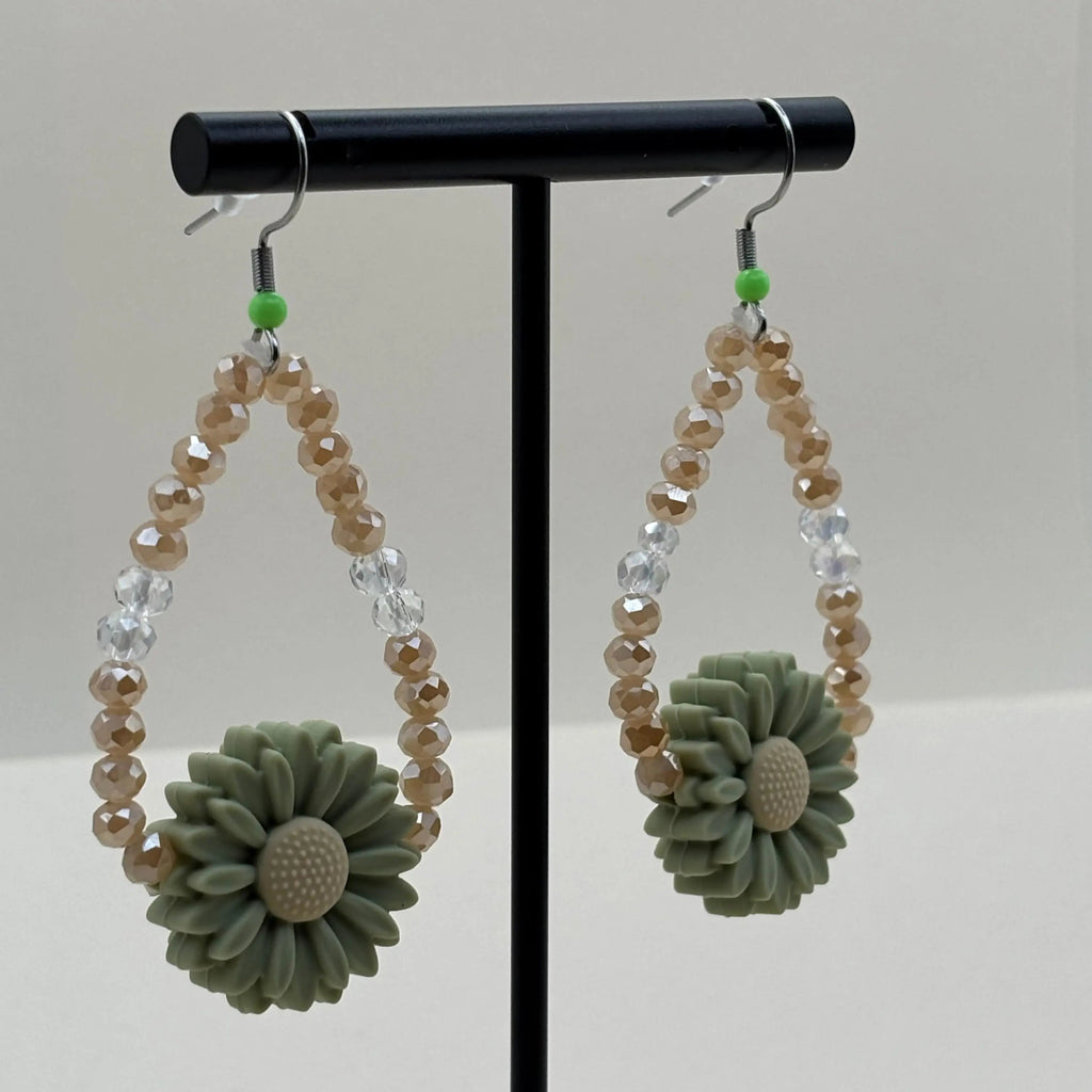 Des boucles d'oreilles pendentif avec breloque marguerite et perles acryliques  marron et bleues