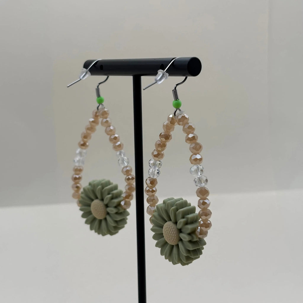 Une paire de boucles d'oreilles pendentif avec breloque marguerite et perles acryliques  marron et bleues