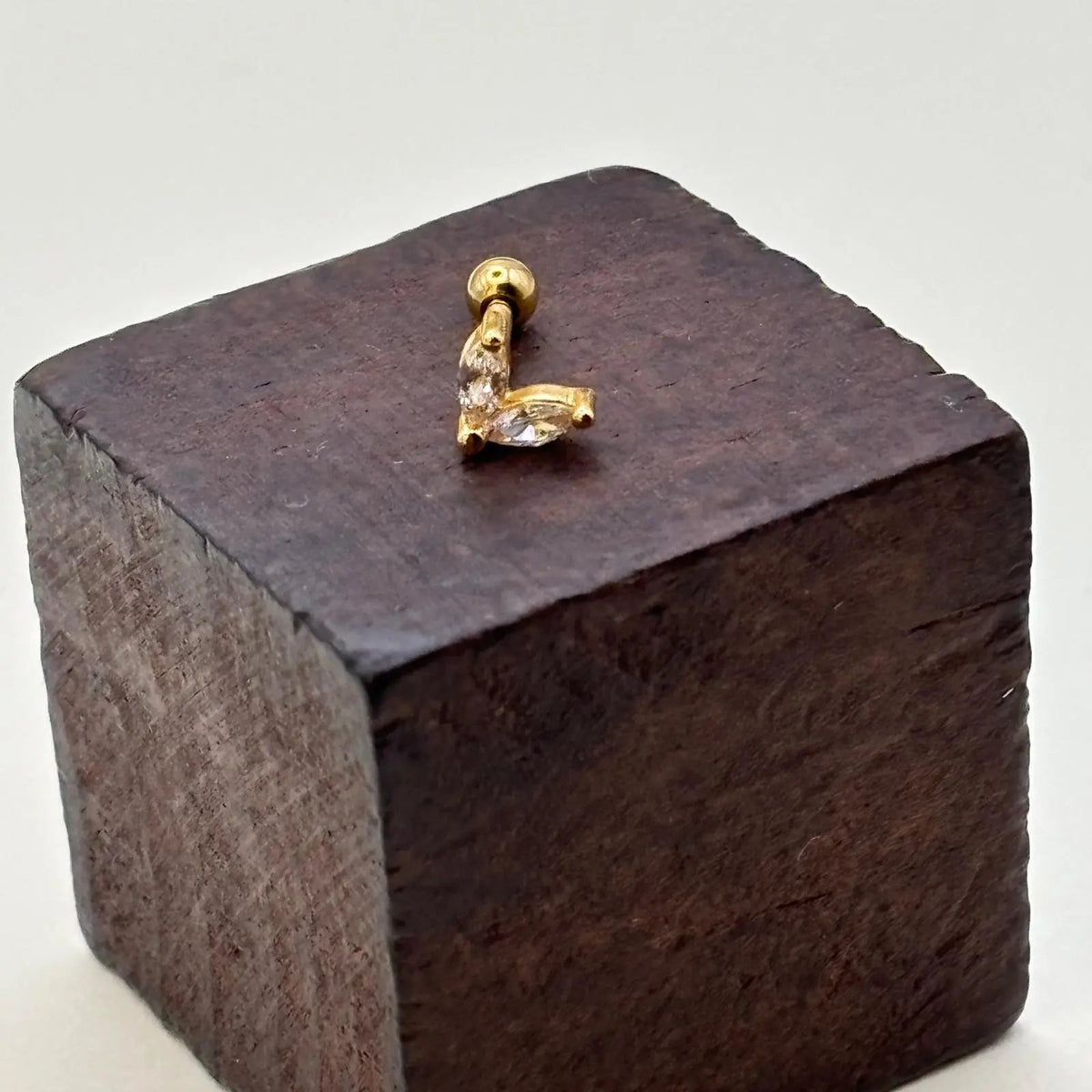 Piercing doré en forme de V avec des strass 