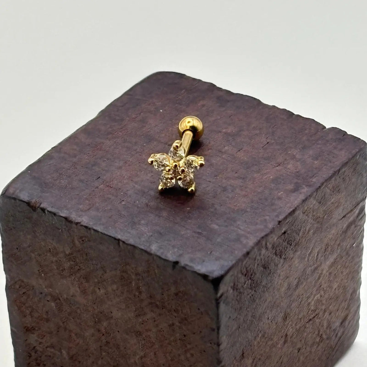 Piercing doré en forme de fleur avec des strass