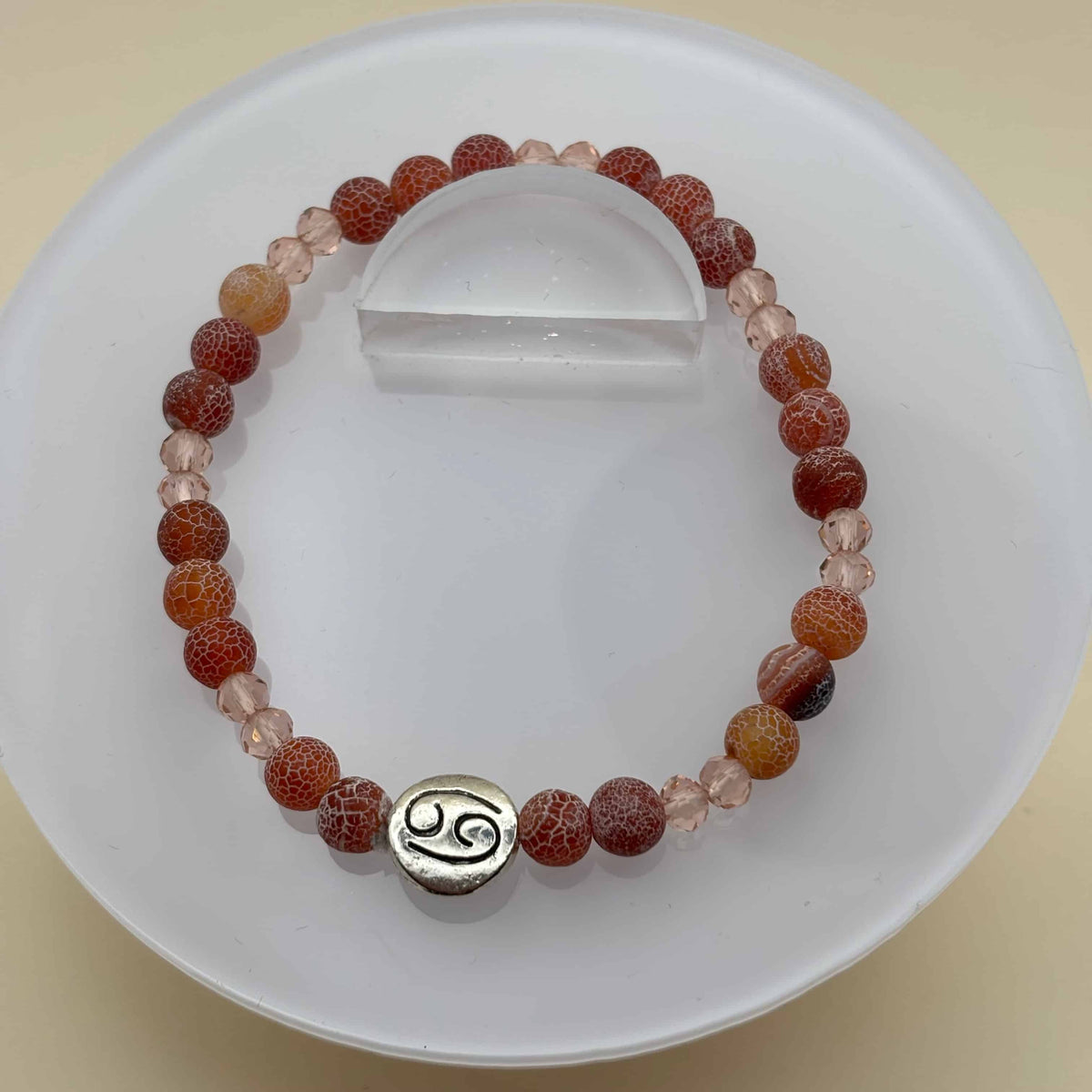 Bracelet en perles sur élastique avec perles en porcelaine et en verre et médaillon avec le signe zodiaque du cancer