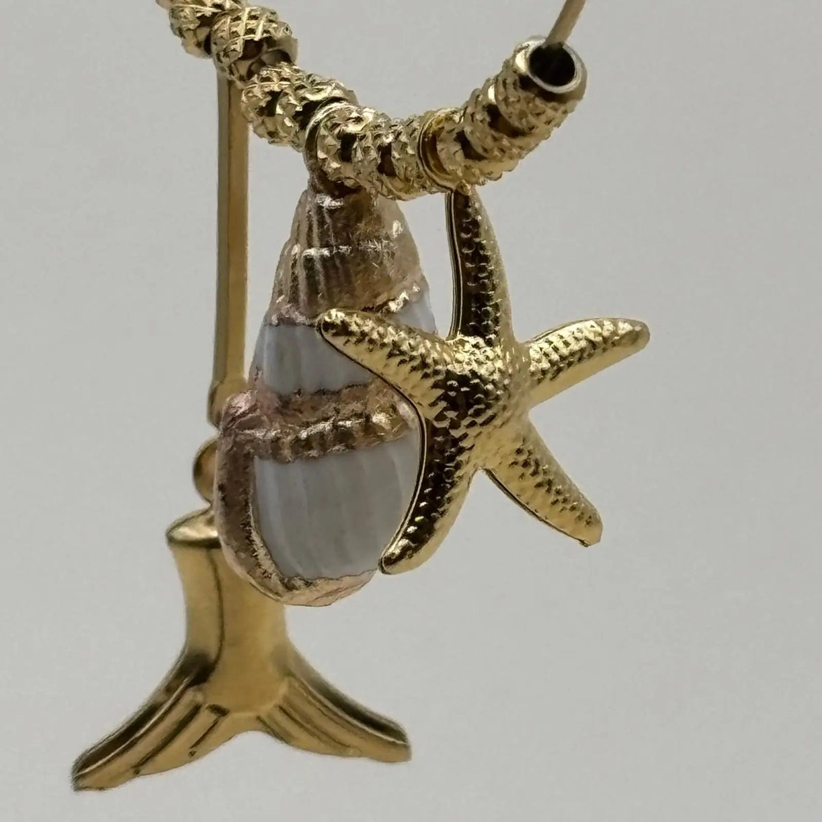Boucles d'oreilles créoles dorées avec breloques coquillage queue de baleine et une étoile de mer