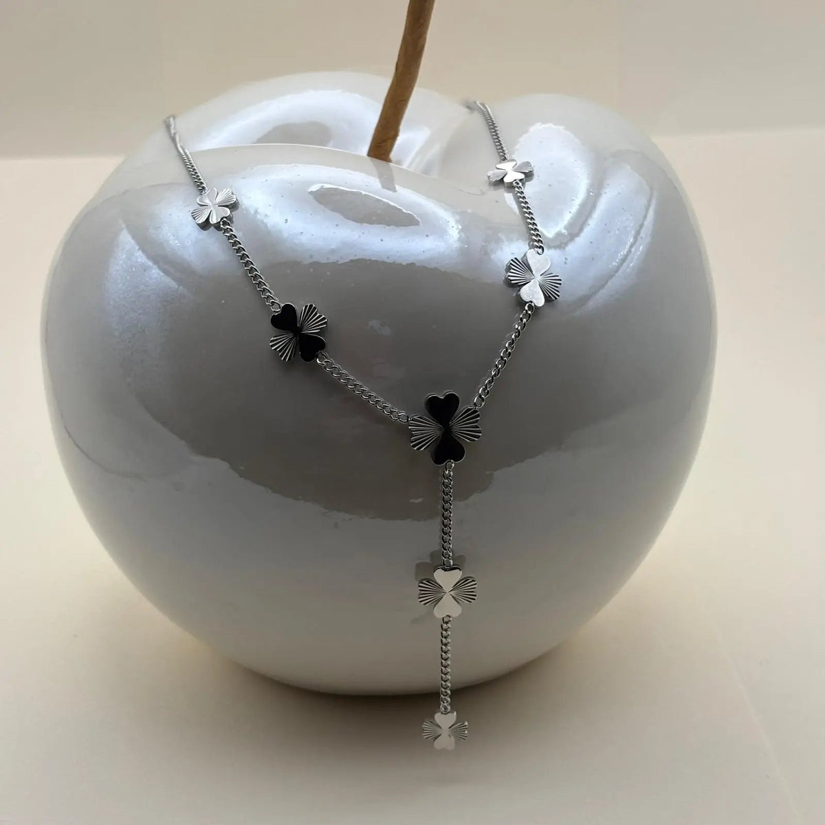 Un collier argenté avec motifs trèfles à quatre feuilles en acier inoxydable 