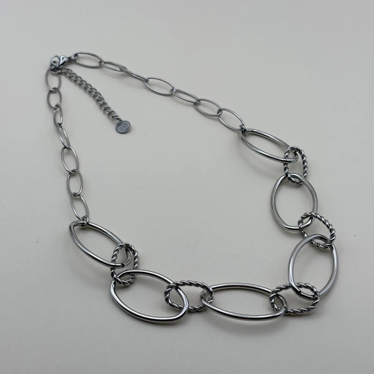 Collier argenté avec anneaux ovales lisses et torsades en acier inoxydable
