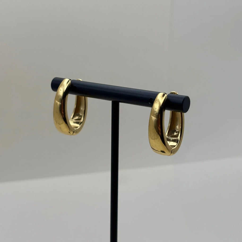 Des boucles d'oreilles dorées en créoles allongées