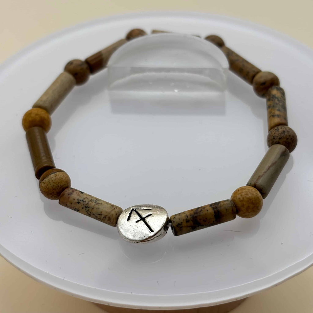 Un bracelet en perles sur élastique avec perles en porcelaine et en verre et médaillon avec le signe du sagittaire