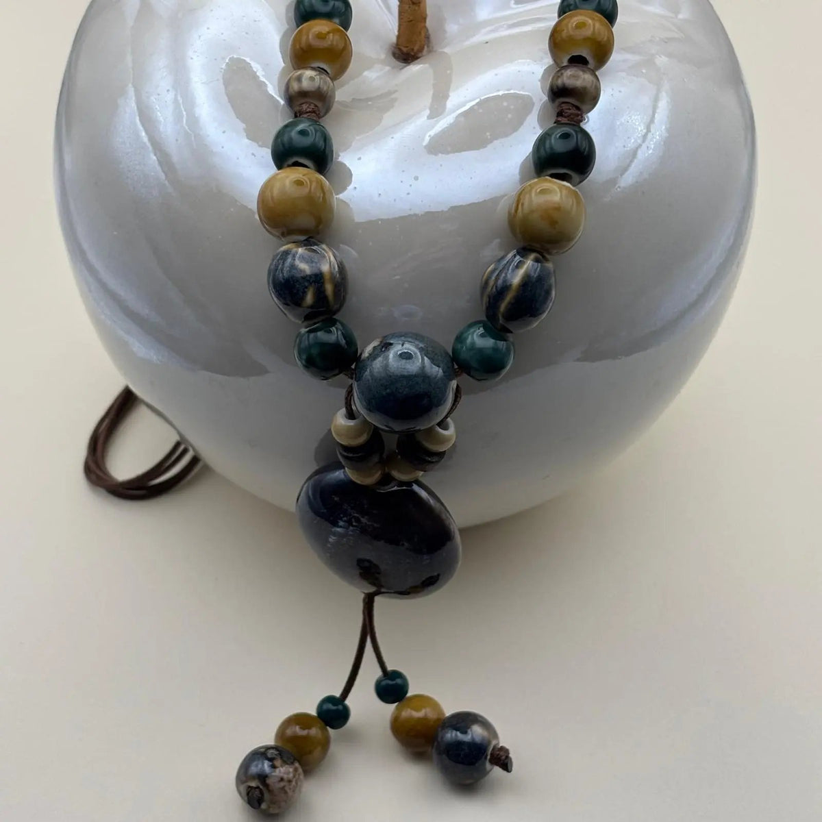 Collier fantaisie ethnique avec un lien en nylon marron réglable avec perles céramique et médaillon couleur bleu canard