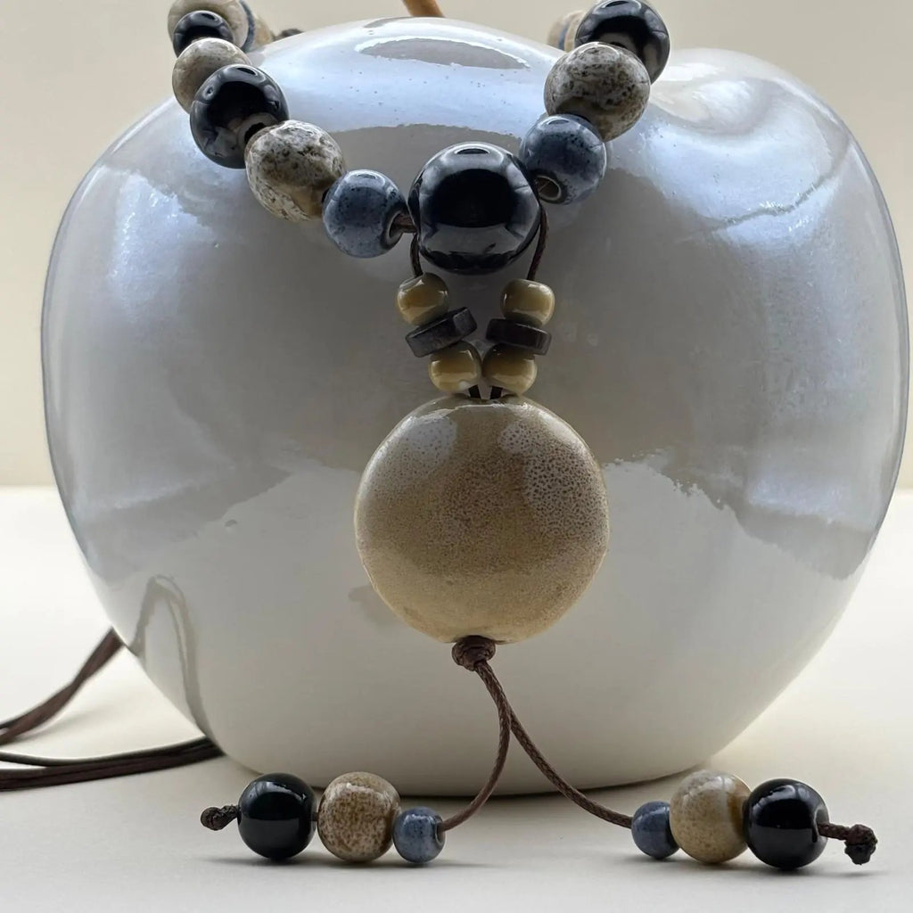 Collier fantaisie ethnique avec lien en nylon marron réglable avec perles céramique et médaillon couleur écru