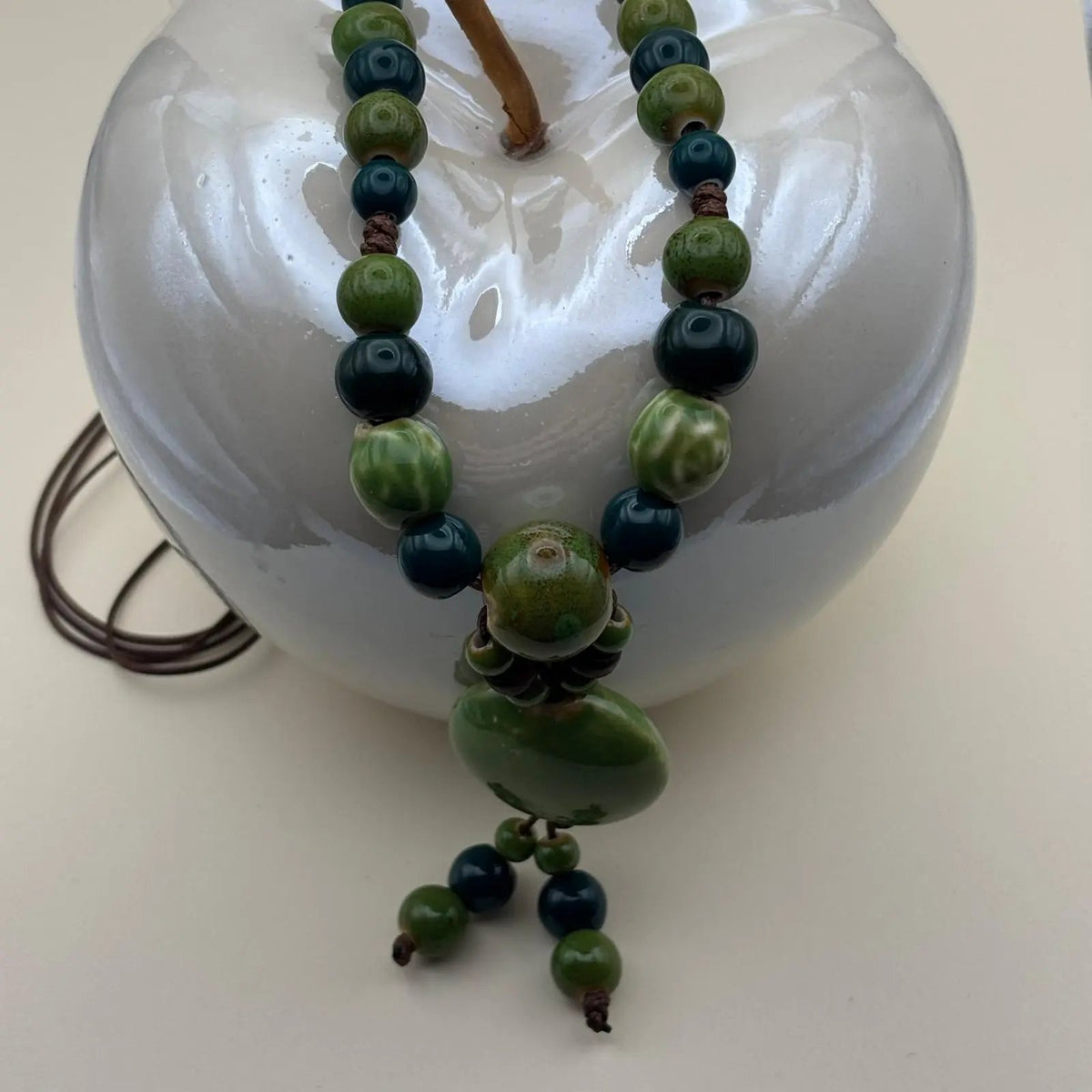 Collier fantaisie ethnique avec un lien en nylon marron réglable avec perles céramique et médaillon couleur verte