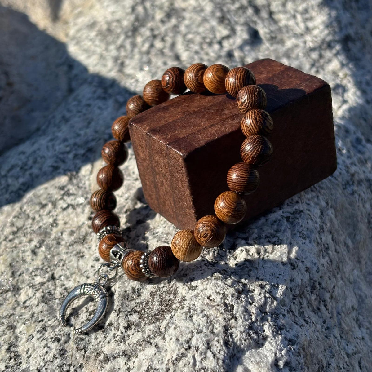 Bracelet en perles artisanal avec une breloque lune argentée et des perles en bois sur élastique