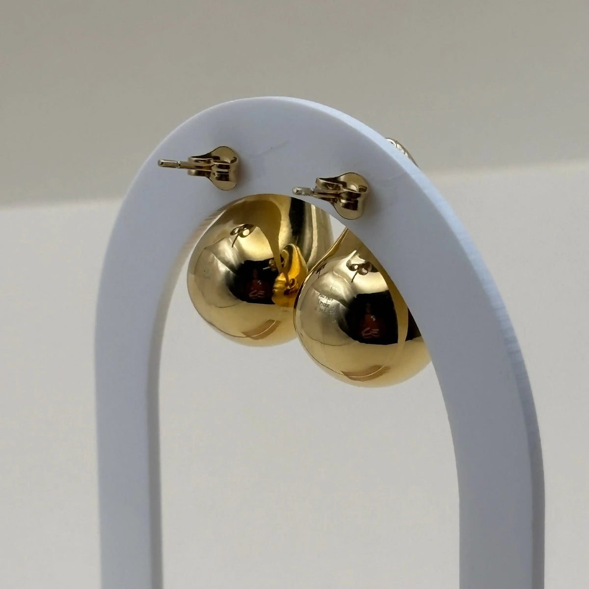 Une paire de boucles d'oreilles dorées en forme de goutte d'eau en acier inoxydable