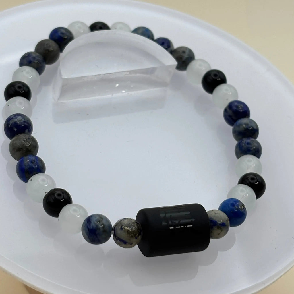 Bracelet composé de perles brunes et de perles argentées hexagonales, terminé par une perle cylindrique noire gravée en son centre