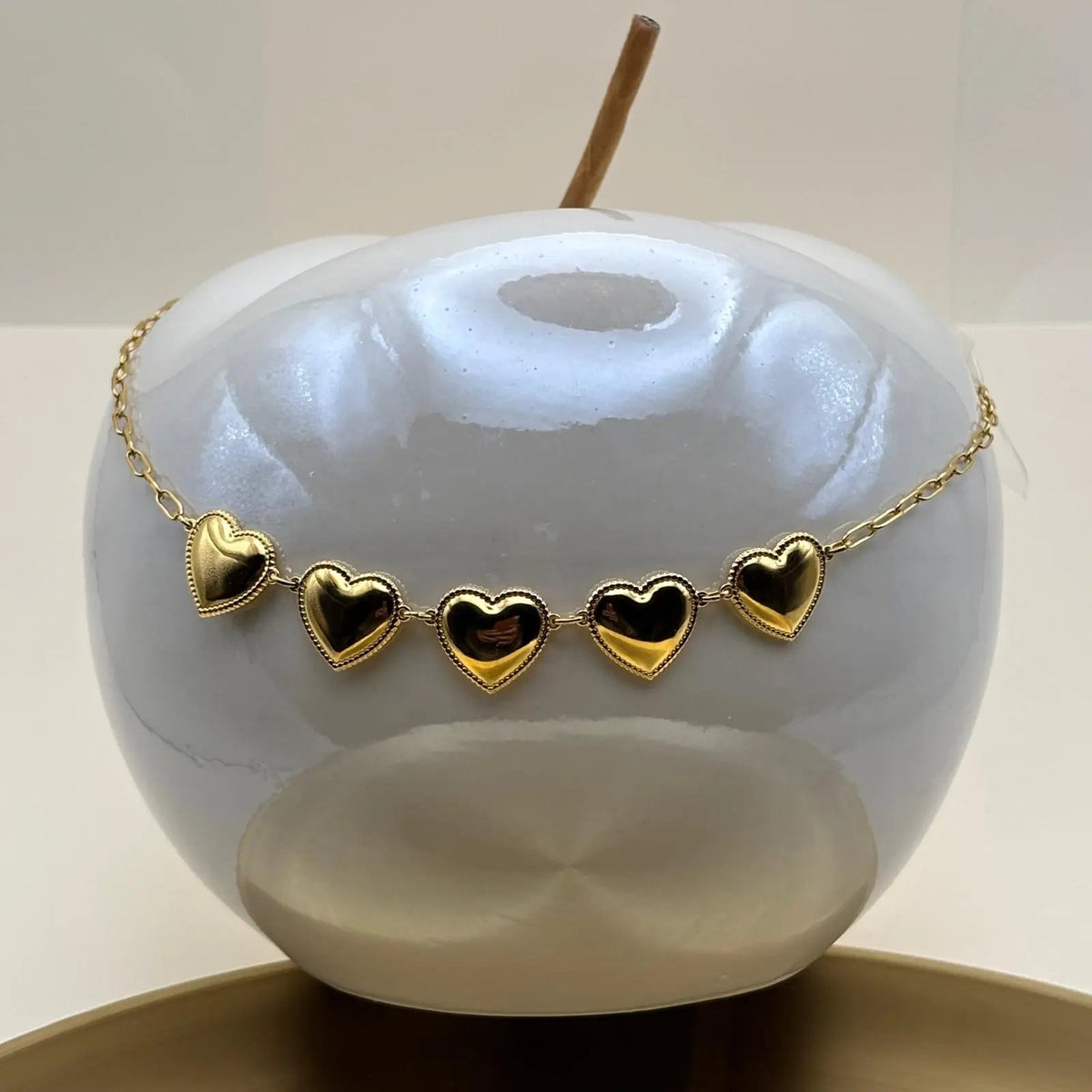 Un collier doré avec cinq coeurs en acier inoxydable