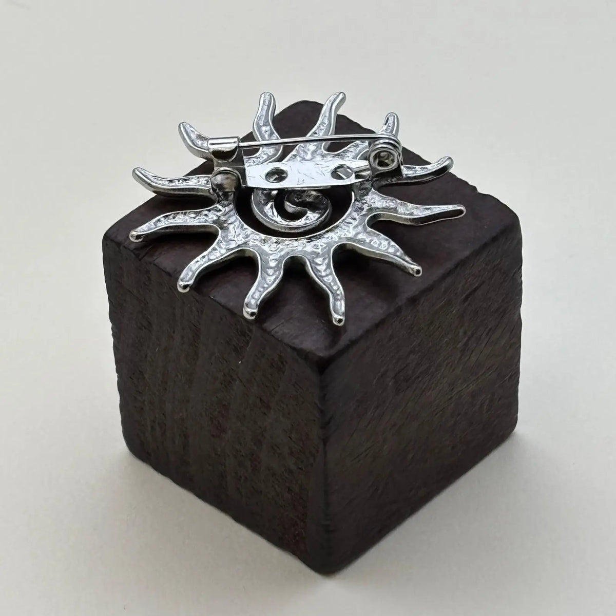 Broche de couleur argentée en forme de soleil 