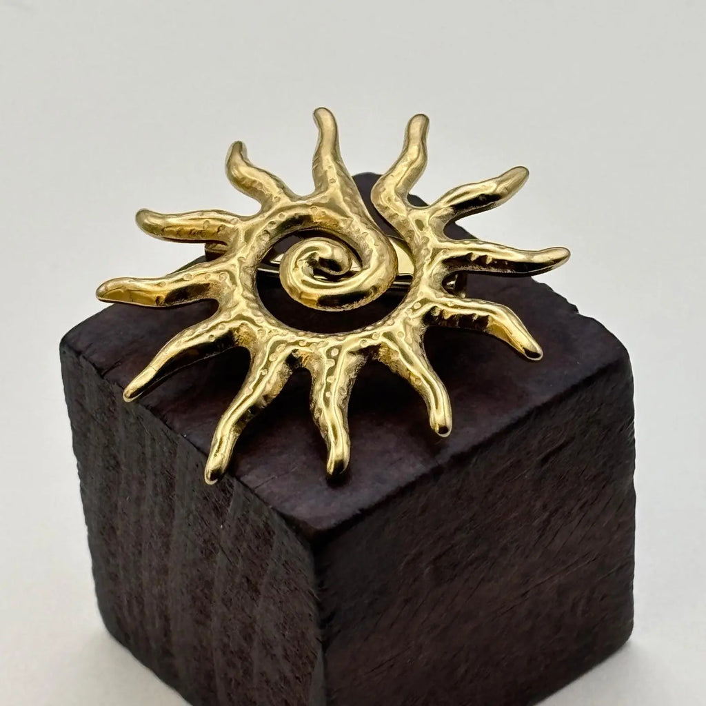 Broche dorée en forme de soleil 