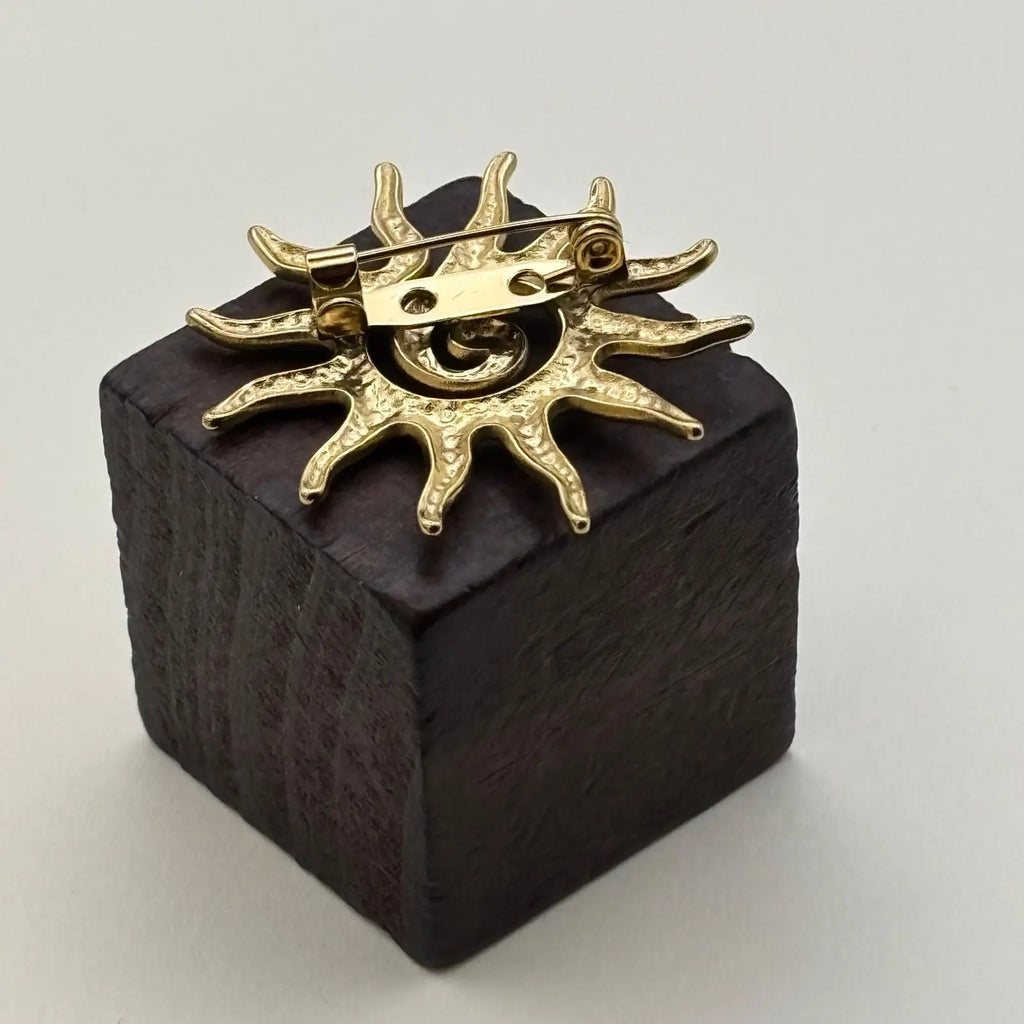 Broche de couleur dorée en forme de soleil 