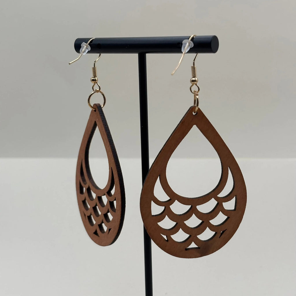 Des boucles d'oreilles avec accroche dorée et boucle en bois en forme d'écaille de poisson vendu sur le site internet prêtes à briller