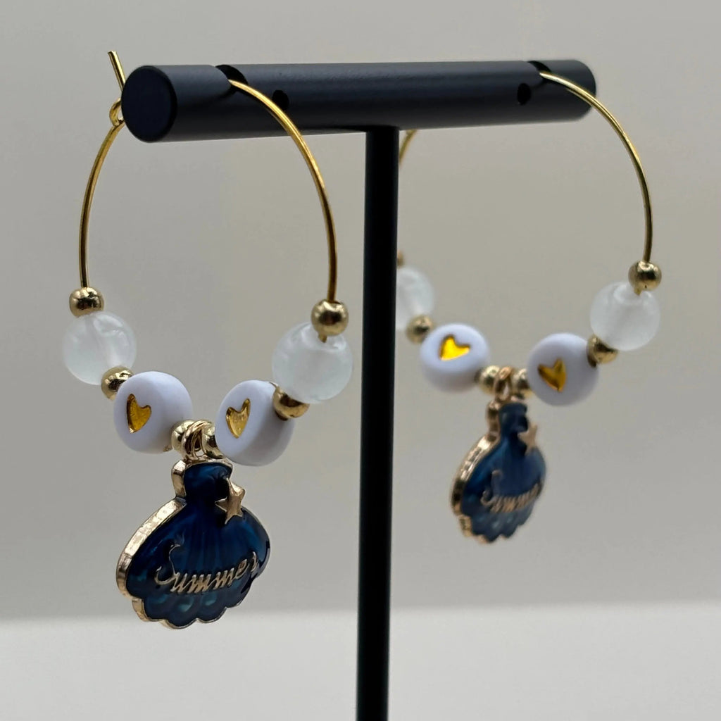 Des boucles d'oreilles créole avec breloque coquillage bleu et mot soleil 