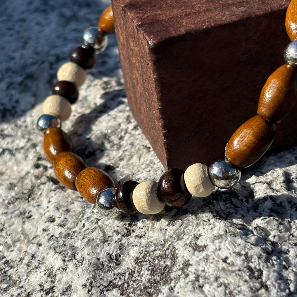 Vue de près d'un bracelet en perles artisanal avec perles de bois et perles acryliques allongées et rondes sur élastique