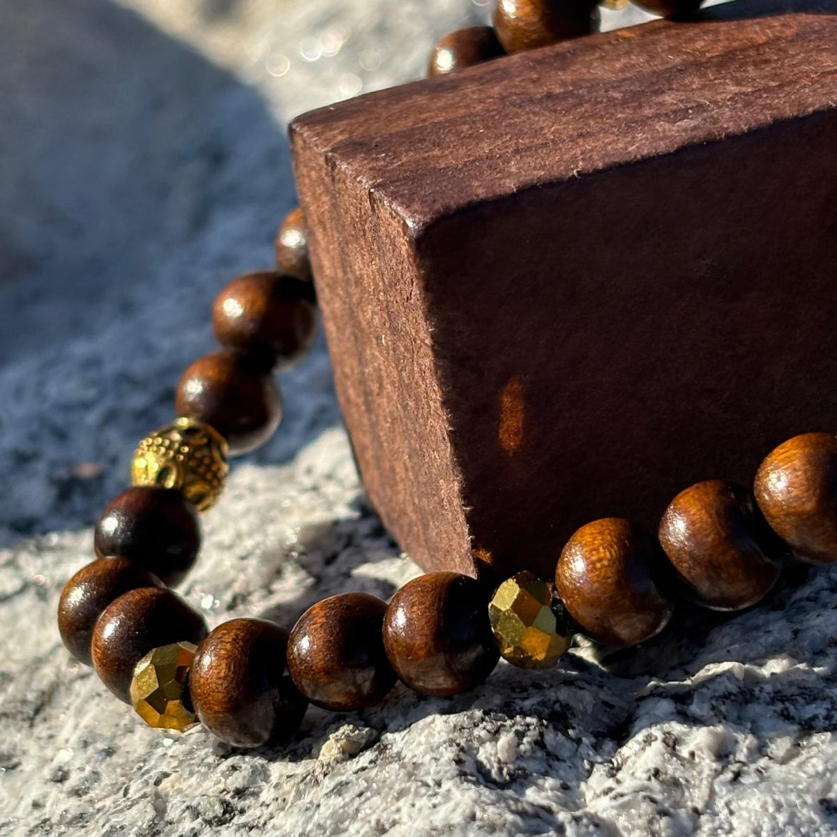 Vue de près d'un bracelet artisanal en perles avec perles ethniques dorées et en bois sur élastique