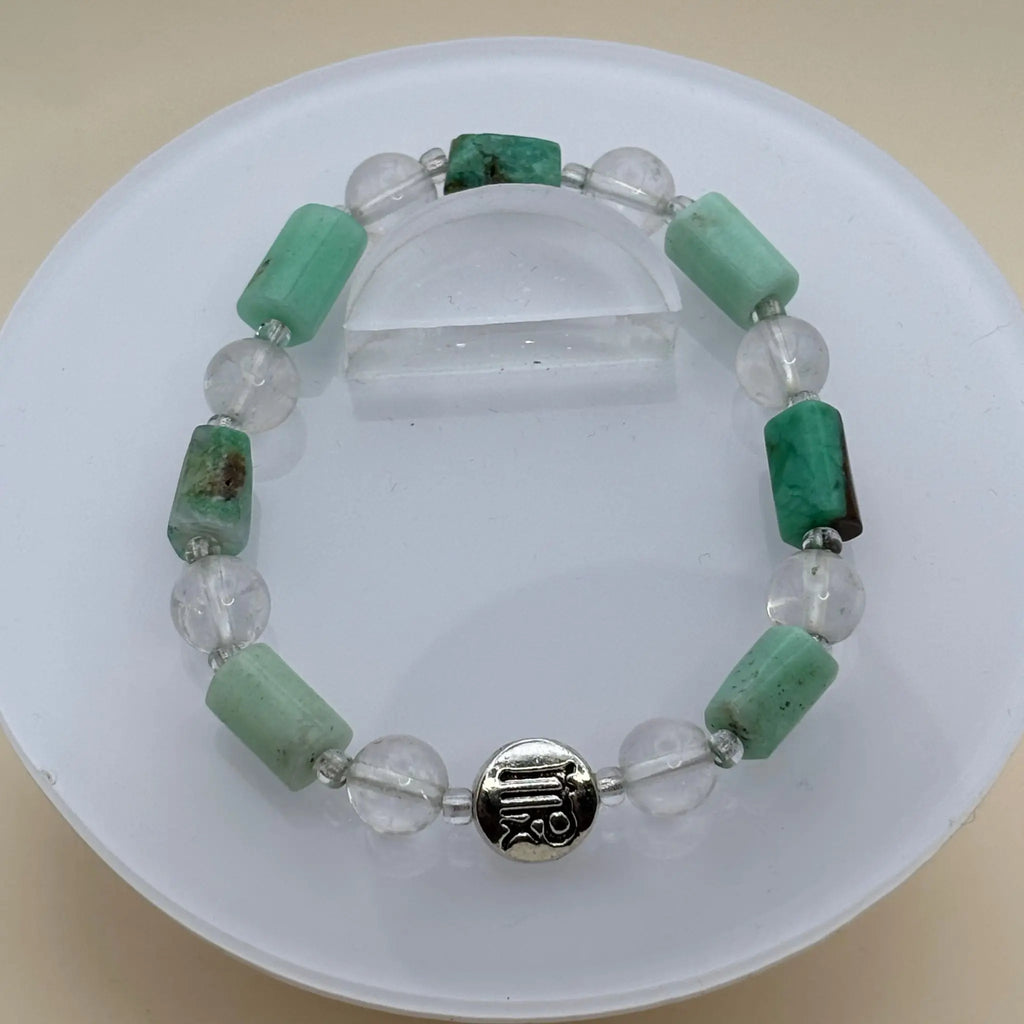 Bracelet combinant perles transparentes et cylindriques vert clair accompagné d’un médaillon argenté gravé