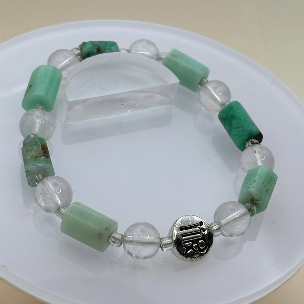 Bracelet alternant perles cylindriques vert clair et perles transparentes avec un médaillon argenté gravé