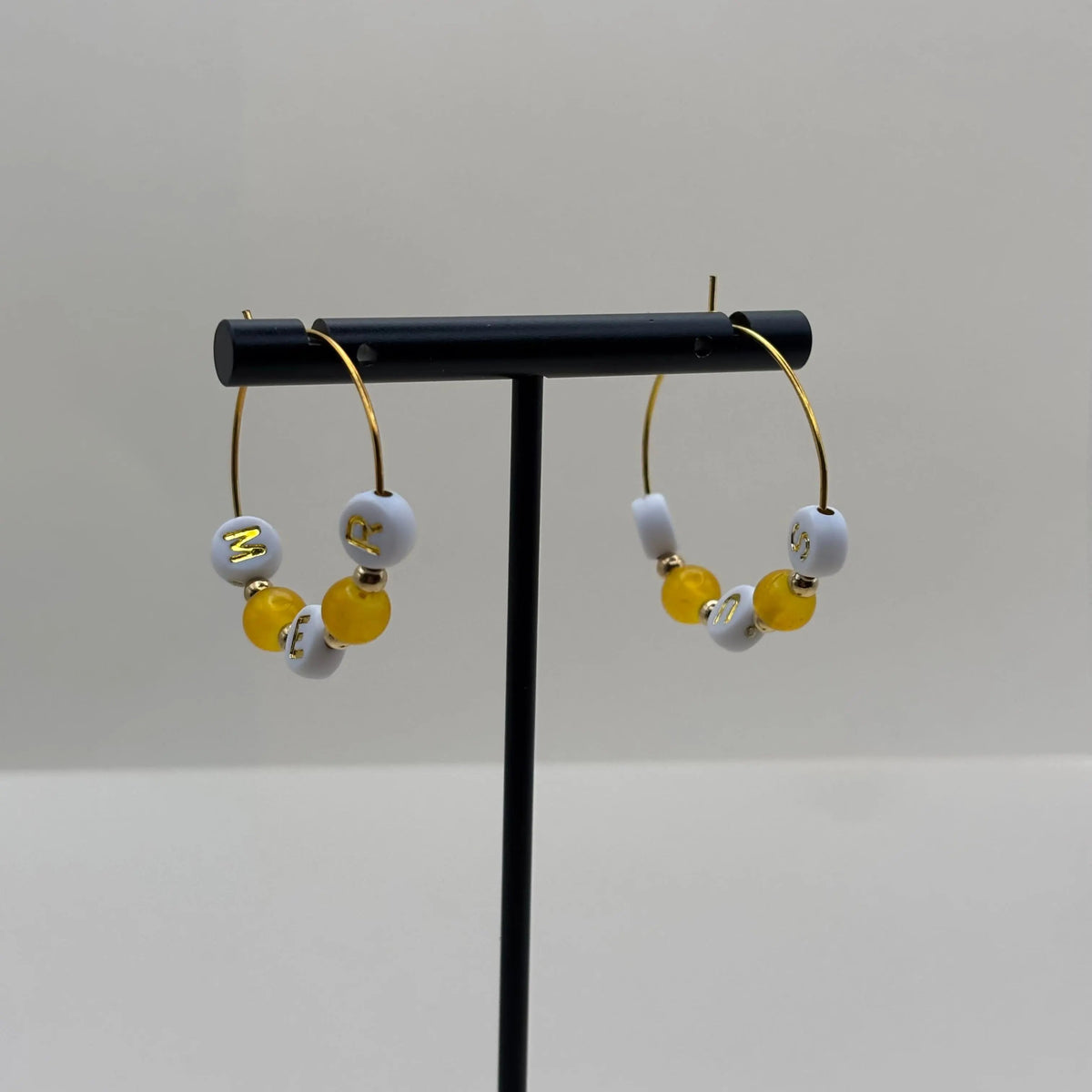 Boucles d'oreilles créoles dorées avec le mot mer sur des perles et des perles oranges 