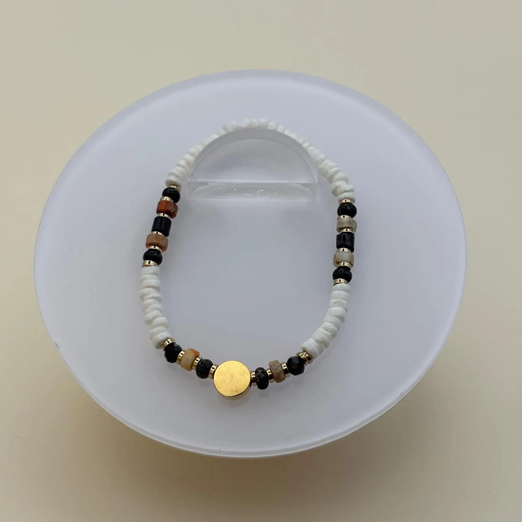 Bracelet artisanal en perles rondes et plates et breloque cercle doré