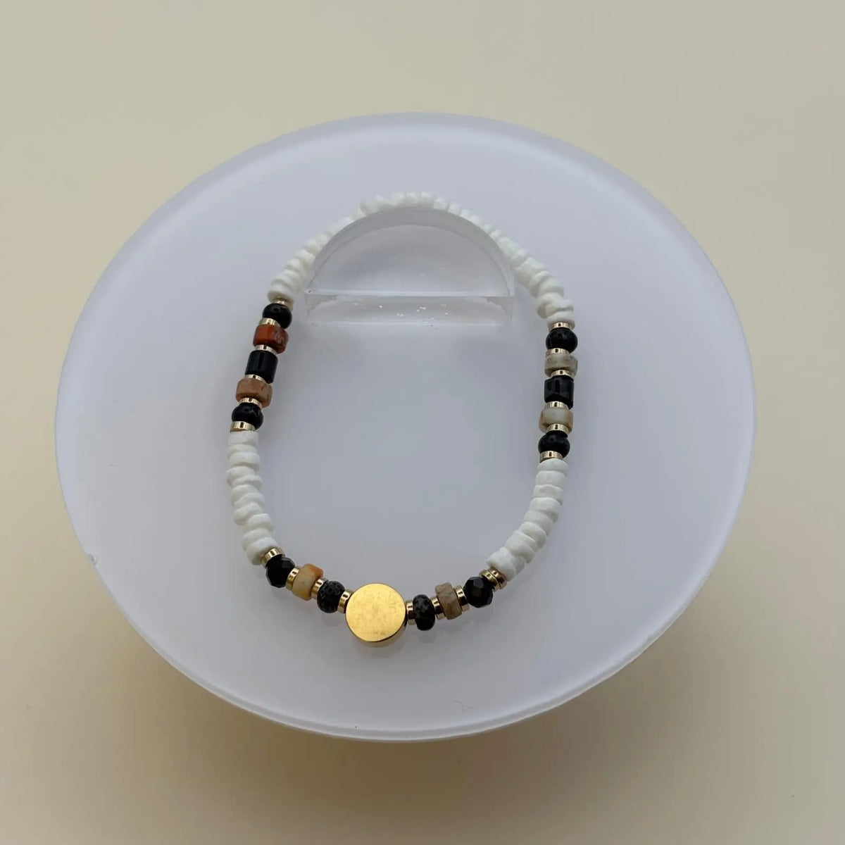 Bracelet artisanal en perles rondes et plates et breloque cercle doré