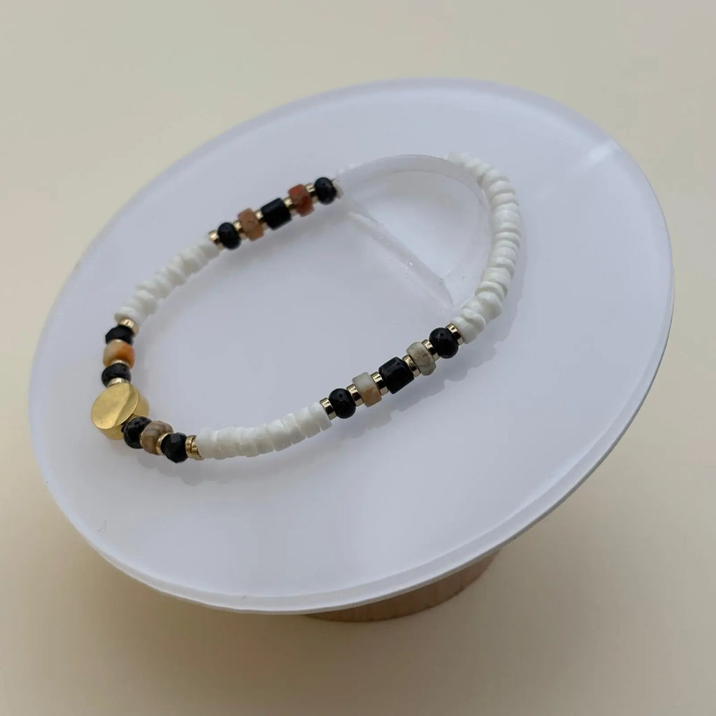 Bracelet artisanal en perles rondes et plates et une breloque cercle plate dorée