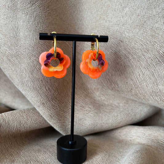 Petites boucles d'oreilles créoles dorées avec fleur couleur orange vendues sur le site internet prêtes à briller