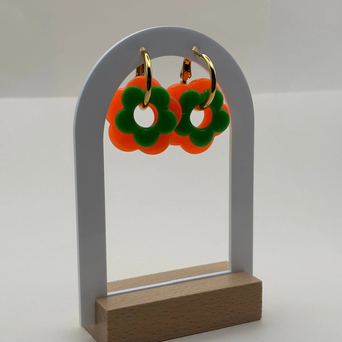 Des petites boucles d'oreilles créoles dorées avec fleur couleur verte 