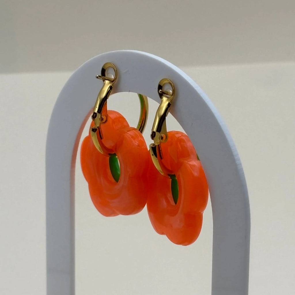 Une paire de petites boucles d'oreilles créoles dorées avec fleur couleur verte 