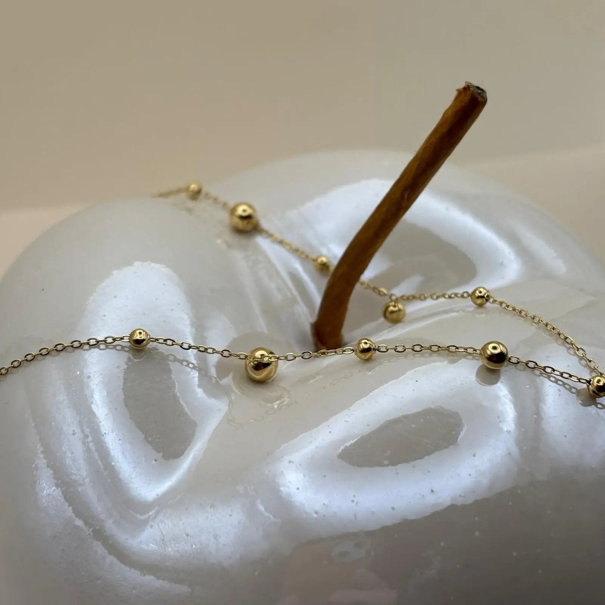 Un collier doré en acier inoxydable avec chaine et perles dorées  