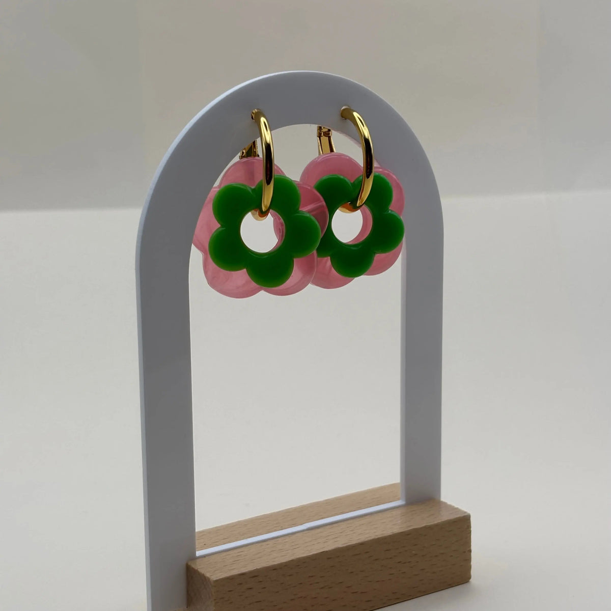 Des petites boucles d'oreilles créoles dorées avec fleur verte