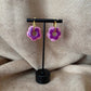 Petites boucles d'oreilles créoles dorées avec fleur violettes vendues sur le site internet prêtes à briller