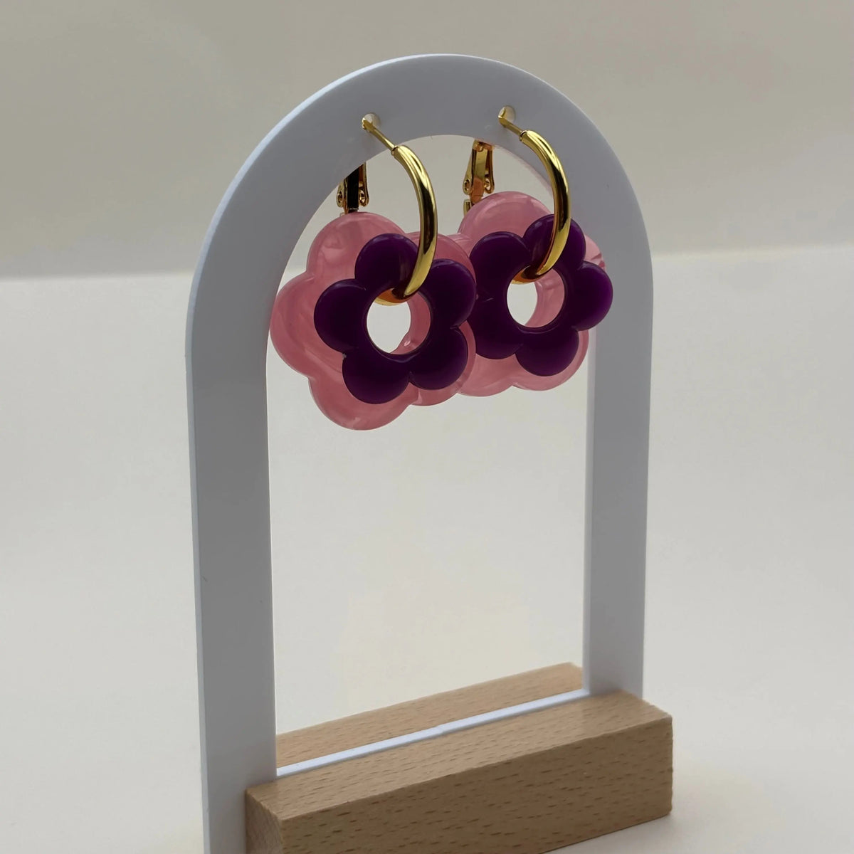 Des petites boucles d'oreilles créoles dorées avec fleur violette