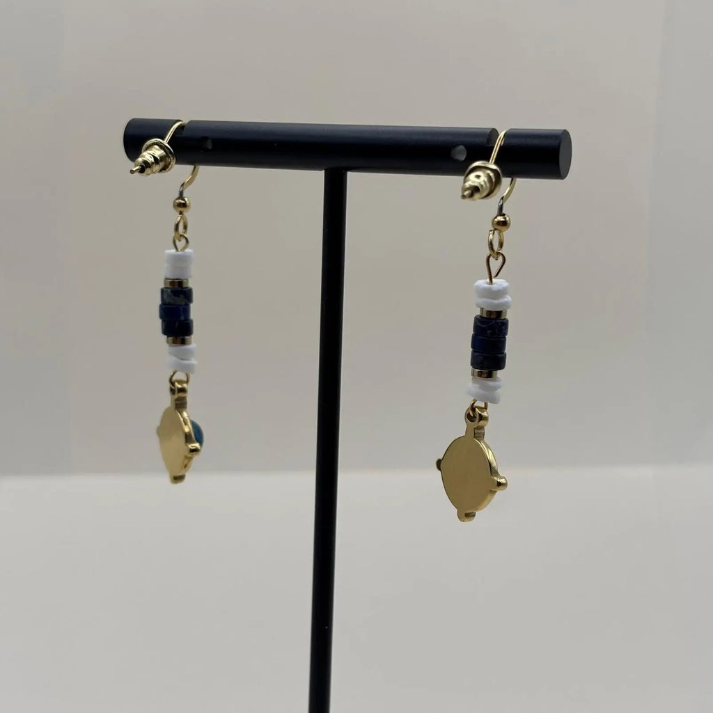 Des boucles d'oreilles artisanales avec attache dorée et breloque bleue et dorée en forme de cercle