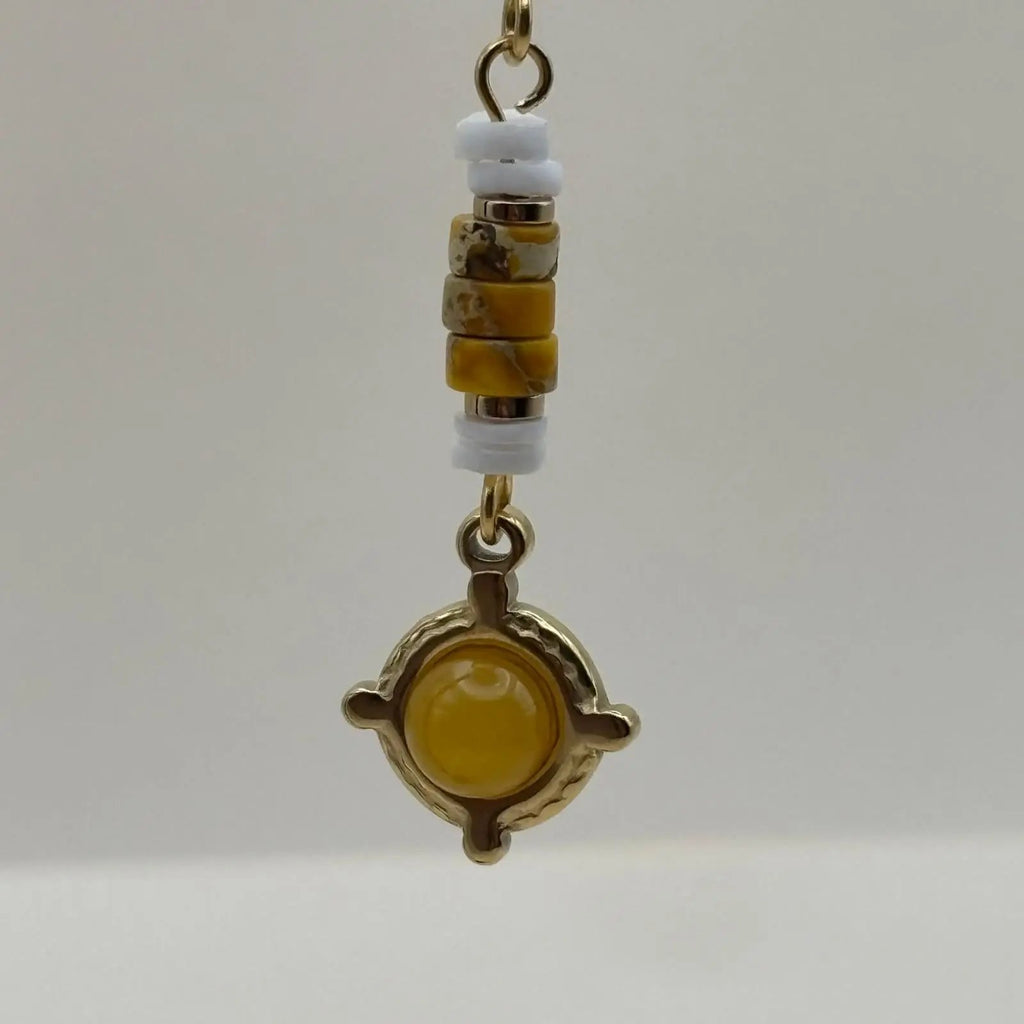 Boucles d'oreilles artisanales avec attache dorée et breloque jaune et dorée en forme de cercle