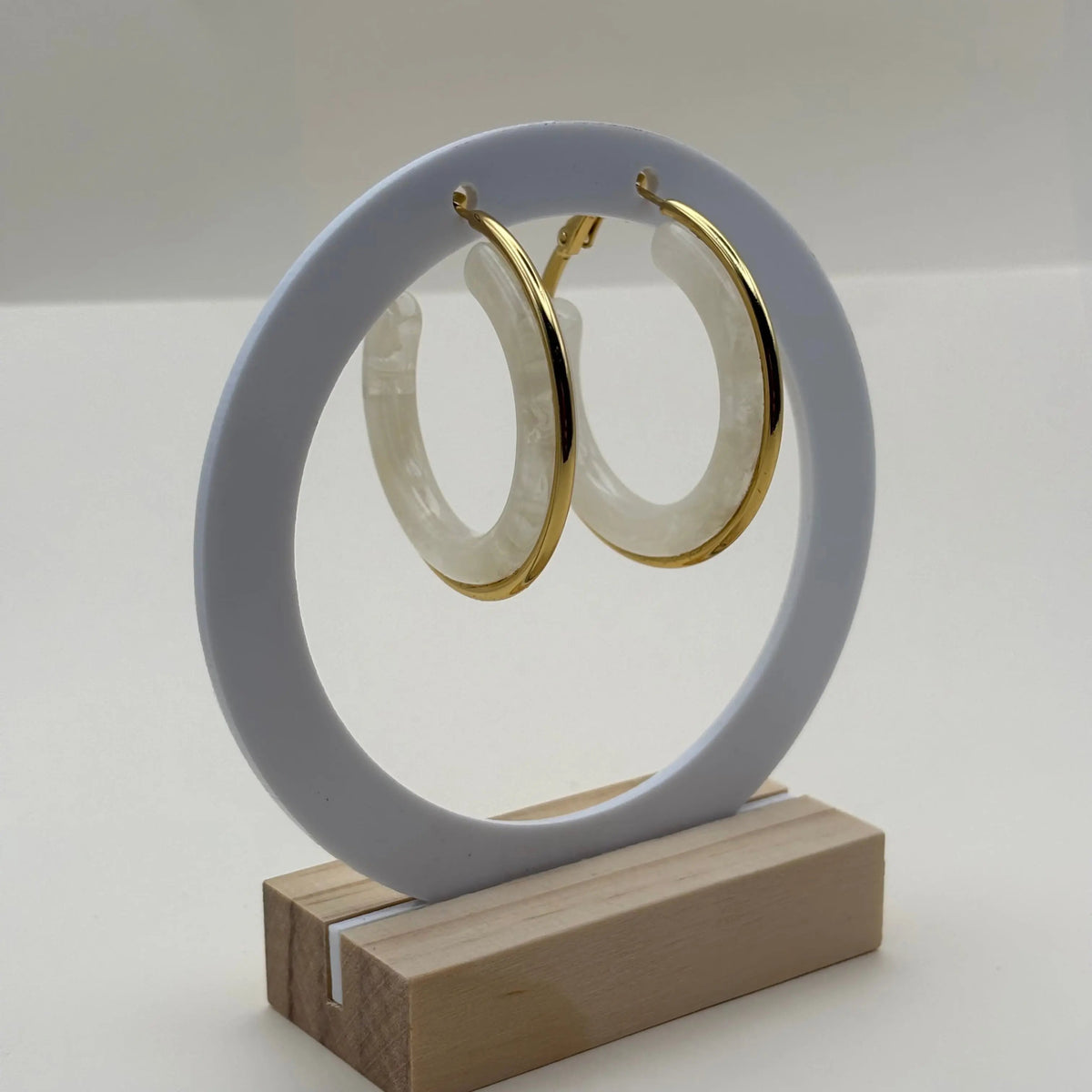 Boucles d'oreilles créoles dorées avec insert d'un anneau blanc