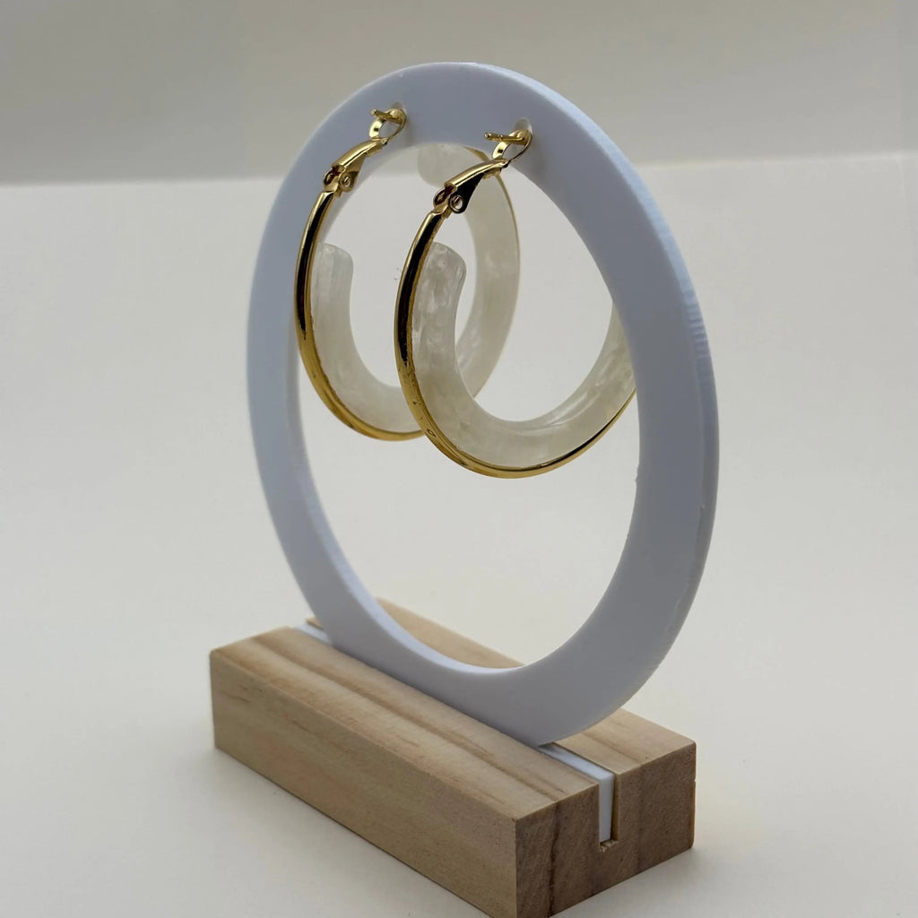 Une paire de boucles d'oreilles créoles dorées avec insert d'un anneau blanc 