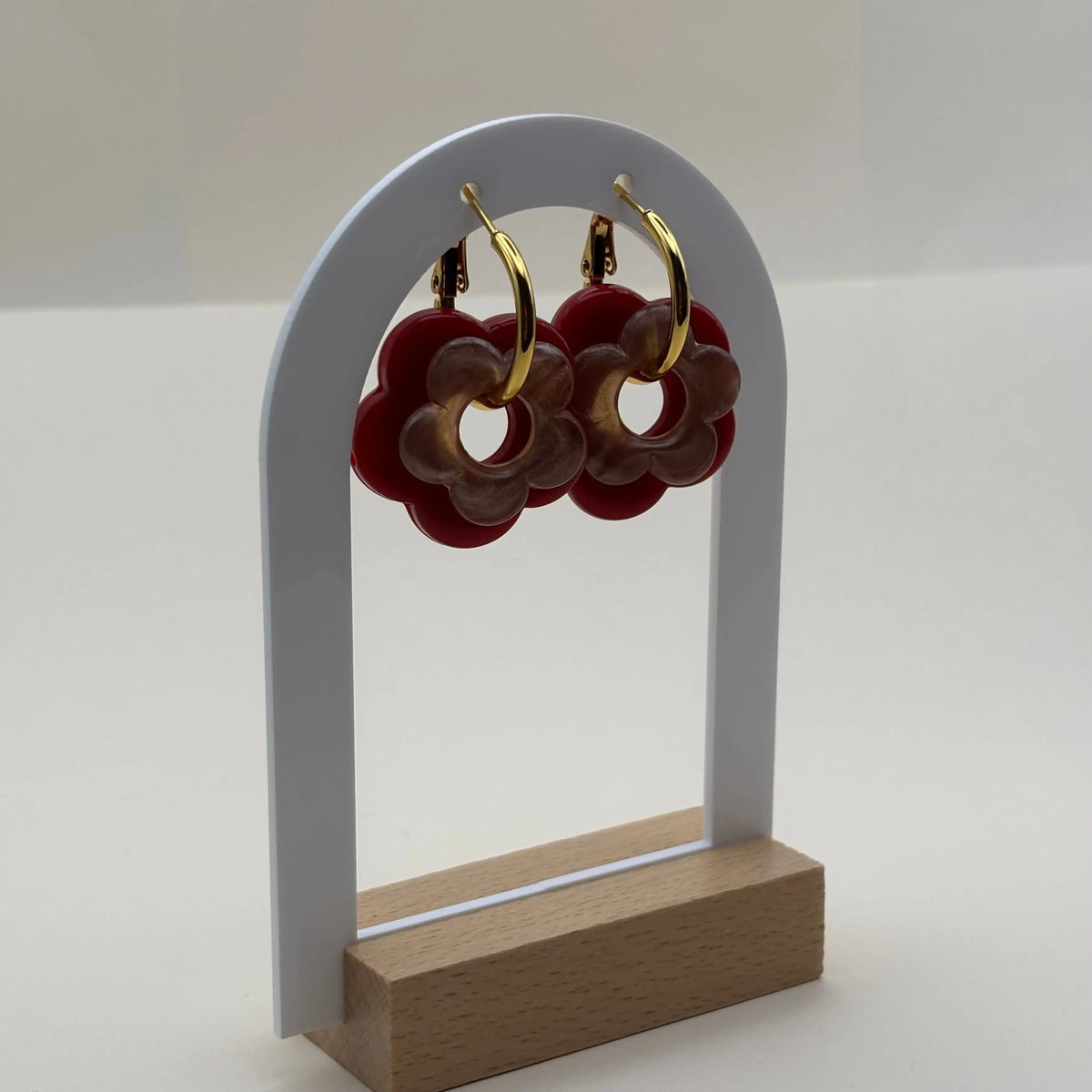 Des petites boucles d'oreilles créoles dorées avec fleurs rouges