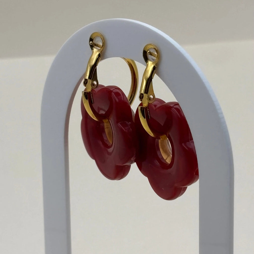 Une paire de petites boucles d'oreilles créoles dorées avec fleurs rouges
