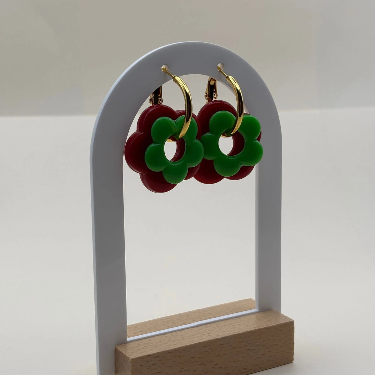 Des petites boucles d'oreilles créoles dorées avec fleur rouge et verte