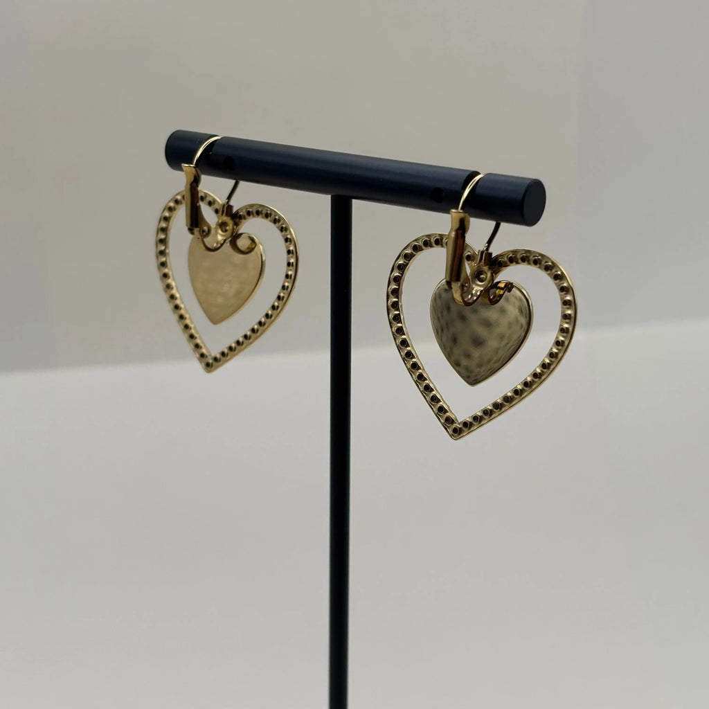 Des boucles d'oreilles dorées avec motif double cœur entouré de strass en acier inoxydable