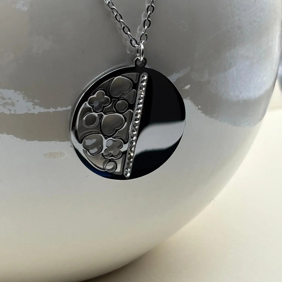 Boucles d'oreilles et pendentif de couleur argentée avec pastille moitié plein moitié avec des motifs géométriques